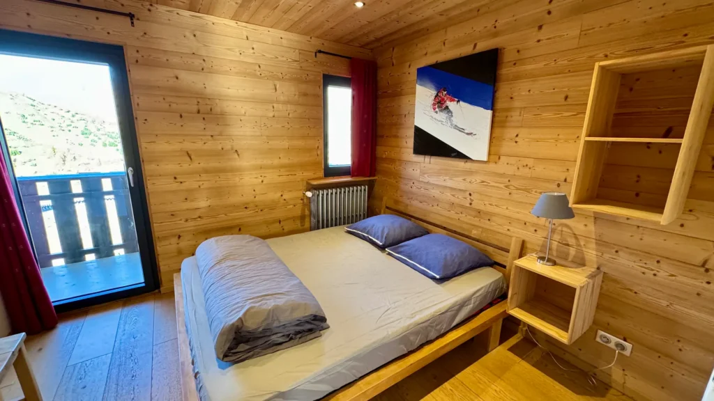 Chambre avec lit double et accès balcon, espace lumineux et confortable avec ouverture sur l’extérieur