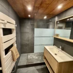 Salle de bain avec douche, évier et sèche-serviettes, espace moderne et fonctionnel pour le confort au quotidien