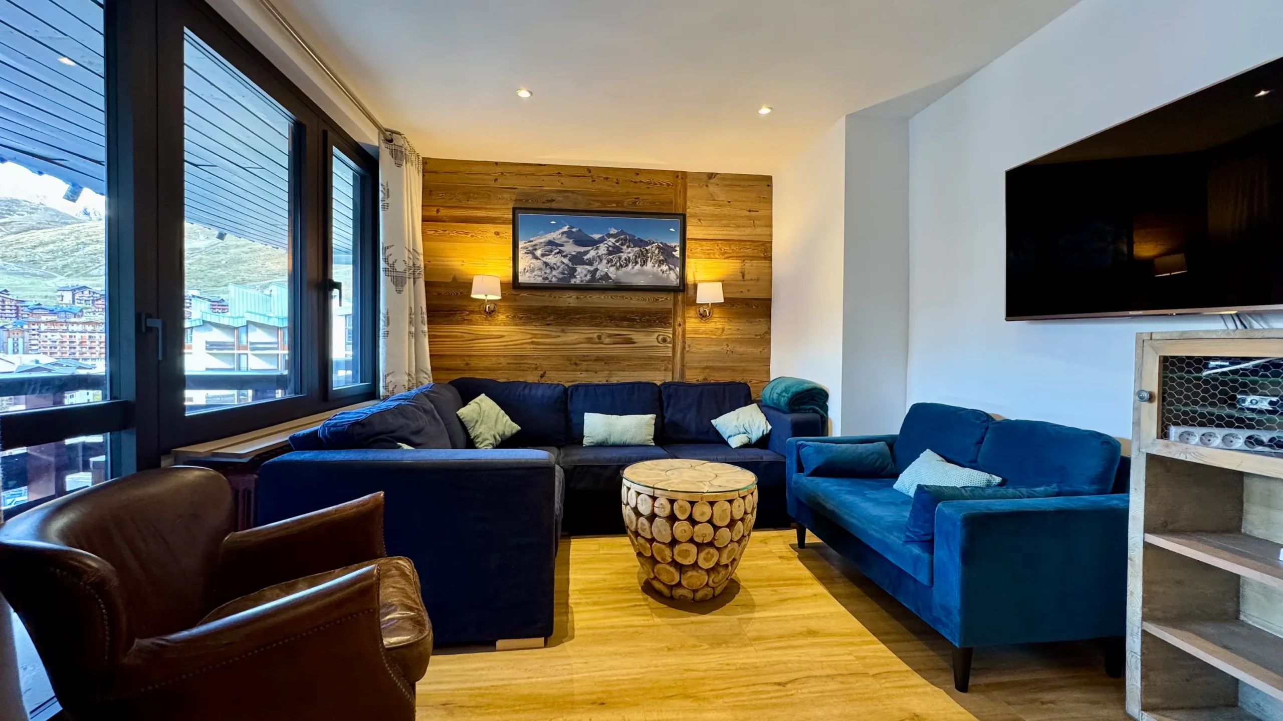 Salon avec grand canapé bleu dans un appartement à louer, espace de vie confortable et lumineux pour se détendre