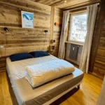 chambre appartement tignes avec lit double et décoration bois vue station