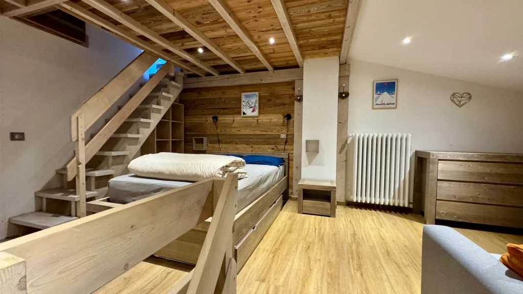 Chambre à Tignes avec lit double et canapé-lit vue sous un autre angle, espace confortable et fonctionnel pour un séjour à la montagne