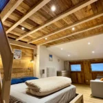 Chambre à Tignes avec lit double et canapé-lit, espace confortable et fonctionnel pour séjour à la montagne