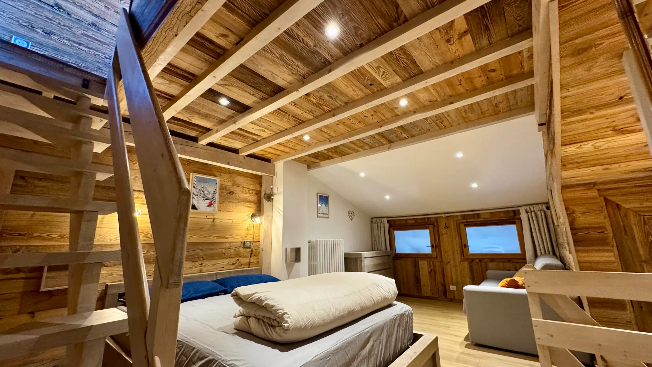 Chambre à Tignes avec lit double et canapé-lit, espace confortable et fonctionnel pour séjour à la montagne