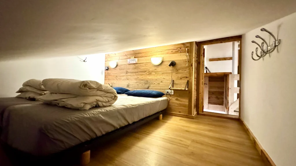 Chambre avec lit double sous un toit bas, espace mansardé cosy et confortable pour un séjour chaleureux