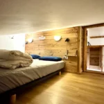 Chambre avec lit double sous un toit bas, espace mansardé cosy et confortable pour un séjour chaleureux
