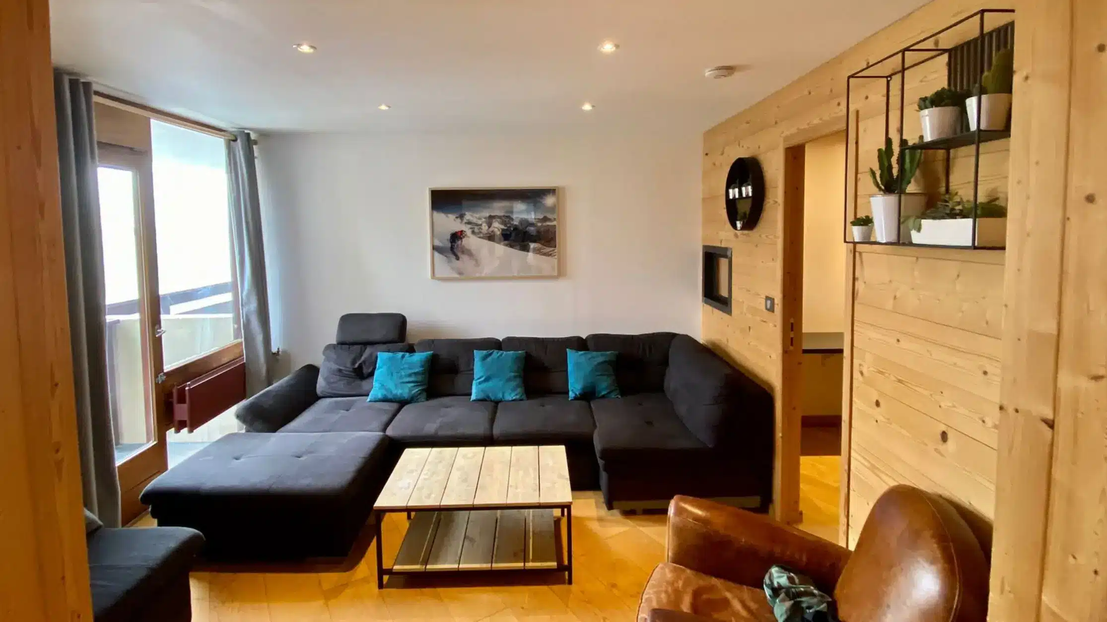 Salon avec canapé et baie vitrée offrant une vue sur les montagnes de Tignes dans un appartement en location