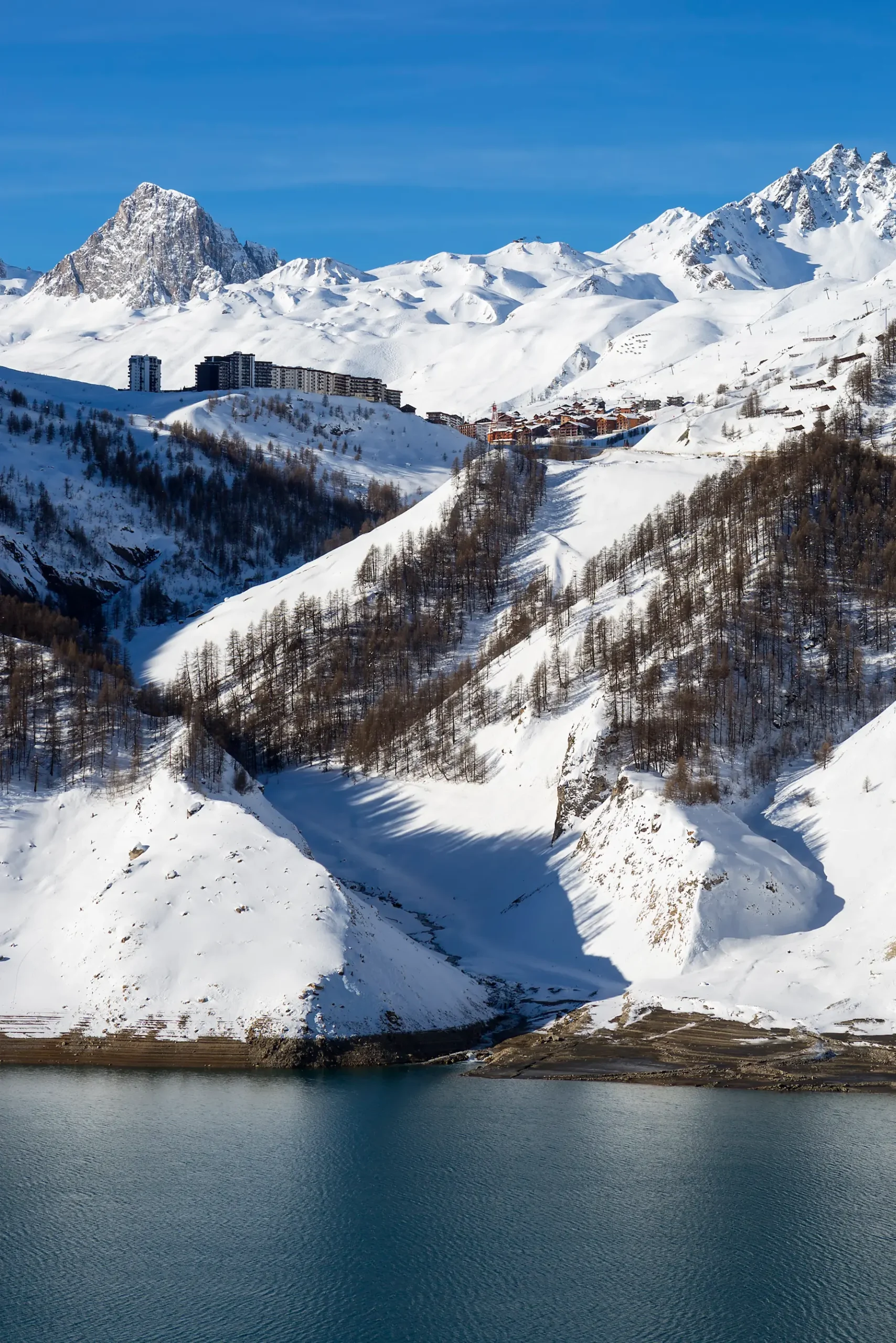 vue sur le lac de tignes avec des paysages enneigées et vue sur la station
