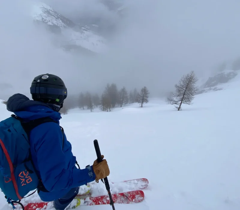 Skieur en pause lors d'une sortie freeride en montagne enneigée