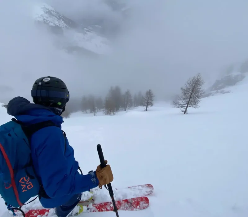 Skieur en pause lors d'une sortie freeride en montagne enneigée