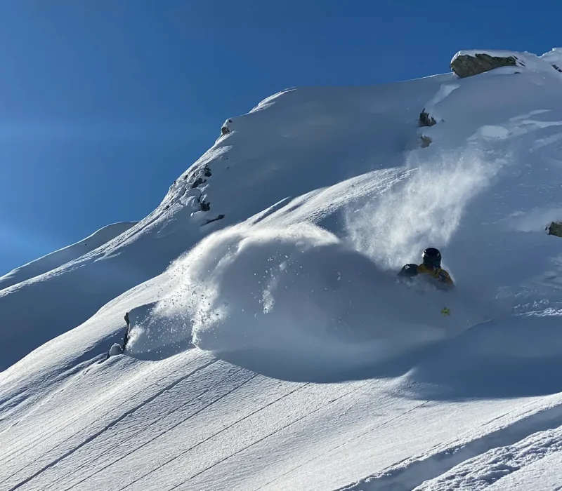Skieur en descente freeride dans la poudreuse à Tignes
