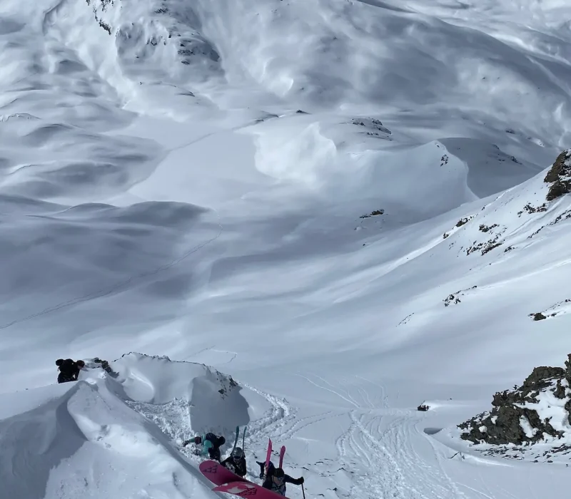 Randonneur à ski gravissant une montagne enneigée avant une descente en freeride