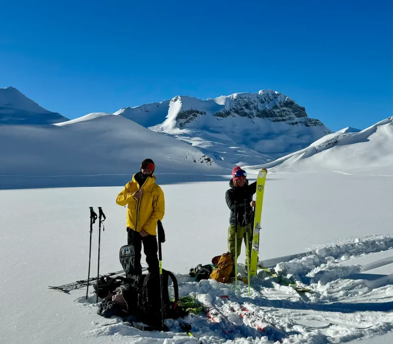Clients en leçon de ski freeride avec un moniteur en montagne